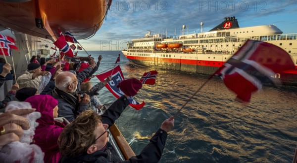 Tourists at the ship's railing, ship MS Finnmarken, Norwegian flags, Mehamn, Finnmark, Norway, Scandinavia, Europe, adventure trip, welcoming the passengers, tourism, Hurtigruten, Hurtigruten trip, cruise, cruise ship, liner, NOR, passenger ship, shipping company Hurtigruten AS, travel, destination, shipping, sea trip, sightseeing, tourism, Norwegian, Norwegian flag, Scandinavian, touristic