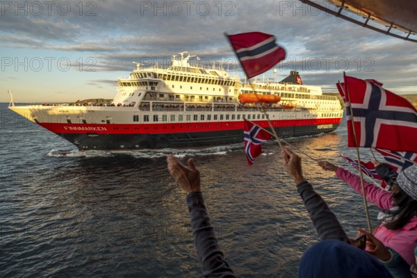 Tourists at the ship's railing, ship MS Finnmarken, Norwegian flags, Mehamn, Finnmark, Norway, Scandinavia, Europe, adventure trip, welcoming the passengers, tourism, Hurtigruten, Hurtigruten trip, cruise, cruise ship, liner, NOR, passenger ship, shipping company Hurtigruten AS, travel, destination, shipping, sea trip, sightseeing, tourism, Norwegian, Norwegian flag, Scandinavian, touristic
