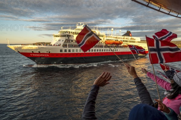 Tourists at the ship's railing, ship MS Finnmarken, Norwegian flags, Mehamn, Finnmark, Norway, Scandinavia, Europe, adventure trip, welcoming the passengers, tourism, Hurtigruten, Hurtigruten trip, cruise, cruise ship, liner, NOR, passenger ship, shipping company Hurtigruten AS, travel, destination, shipping, sea trip, sightseeing, tourism, Norwegian, Norwegian flag, Scandinavian, touristic