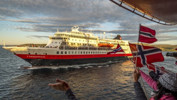Tourists at the ship's railing, ship MS Finnmarken, Norwegian flags, Mehamn, Finnmark, Norway, Scandinavia, Europe, adventure trip, welcoming the passengers, tourism, Hurtigruten, Hurtigruten trip, cruise, cruise ship, liner, NOR, passenger ship, shipping company Hurtigruten AS, travel, destination, shipping, sea trip, sightseeing, tourism, Norwegian, Norwegian flag, Scandinavian, touristic