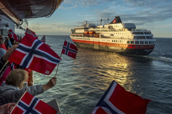 Tourists at the ship's railing, ship MS Finnmarken, Norwegian flags, Mehamn, Finnmark, Norway, Scandinavia, Europe, adventure trip, welcoming the passengers, Berlevåg, tourism, Hurtigruten, Hurtigruten voyage, cruise, cruise ship, liner service, NOR, passenger ship, shipping company Hurtigruten AS, travel, destination, shipping, sea voyage, sightseeing, tourism, Norwegian, Norwegian flag, Scandinavian, touristic