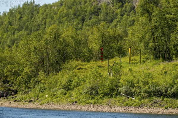 Border Norway-Russia, border posts, yellow border post Norway, red-green border post Russia, Kirkenes, Finnmark, Norway, Scandinavia, Europe, adventure trip, bowøynes, tourism, border markers, border stones, Hurtigruten, Hurtigruten trip, cruise, land border, NOR, travel, travel destination, sea trip, sightseeing, national border, tourism, forest area, Norwegian, Scandinavian, touristic