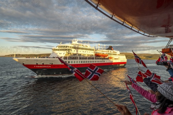 Tourists at the ship's railing, ship MS Finnmarken, Norwegian flags, Mehamn, Finnmark, Norway, Scandinavia, Europe, adventure trip, welcoming the passengers, tourism, Hurtigruten, Hurtigruten trip, cruise, cruise ship, liner, NOR, passenger ship, shipping company Hurtigruten AS, travel, destination, shipping, sea trip, sightseeing, tourism, Norwegian, Norwegian flag, Scandinavian, touristic