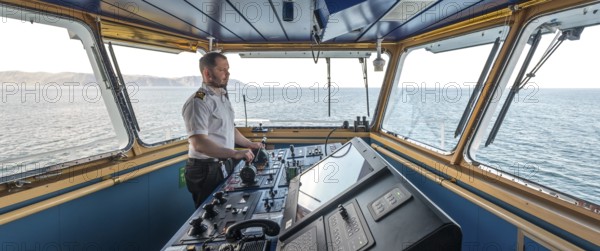 MS Polarlys, command bridge, officer on bridge, Honningsvåg, Finnmark, Norway, Scandinavia, Europe, adventure travel, tourism, Honningsvåg, Hurtigruten, Hurtigruten voyage, command post, cruise, cruise ship, NOR, navigation technology, travel, destination, ship, shipping, ship bridge, ship officer, sea voyage, sightseeing, controls, tourism, Norwegian, Scandinavian, touristic