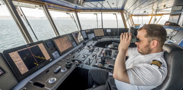 MS Polarlys, command bridge, officer on bridge, Honningsvåg, Finnmark, Norway, Scandinavia, Europe, adventure travel, binoculars, tourism, Honningsvåg, Hurtigruten, Hurtigruten voyage, command post, cruise, cruise ship, NOR, navigation technology, travel, destination, ship, shipping, ship's bridge, ship's officer, sea voyage, sighting, sightseeing, controls, tourism, Norwegian, Scandinavian, touristic