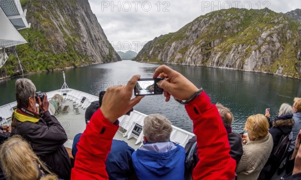Cruise in a fjord, ship bow, photographing tourists, Digermulen, Nordland, Norway, Scandinavia, Europe, adventure trip, mountains, mountainside, mountain ridge, rock faces, fjord, tourism, mountains, mountain range, mountain landscape, mountain range, Hurtigruten, Hurtigruten voyage, cruise, cruise ship, liner, NOR, passenger ship, journey, destination, shipping, sea voyage, sightseeing, escarpment, tourism, tourists, Norwegian, Scandinavian, touristic