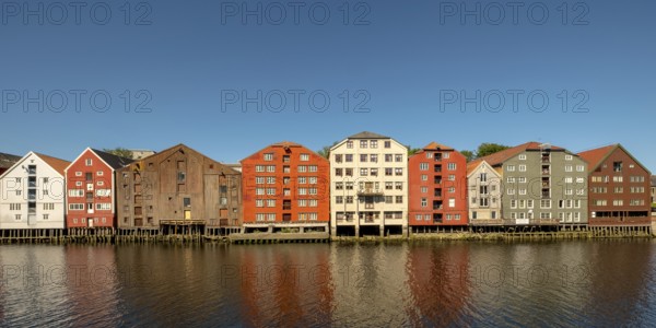 Warehouse city, picturesque colourful houses and commercial buildings on the river Nidelva, pile dwellings, Trondheim, Trøndelag, Norway, Scandinavia, Europe, adventure travel, tourism, gastronomy, commercial buildings, commercial district, property tax, commercial buildings, Hurtigruten, Hurtigruten trip, real estate, cruise, NOR, travel, destination, sea voyage, sightseeing, warehouses, tourism, Trøndelag, residential area, living and living, residential area, residential buildings, residential quality, residential quarter, housing estate, blue sky, colourful house facades, near the bridge Gamle Bybro, Norwegian, Scandinavian, touristy