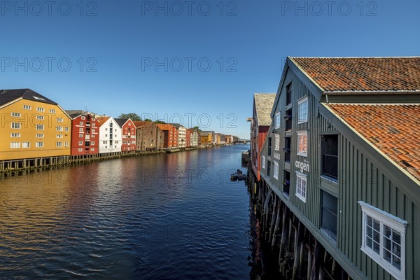 Warehouse city, picturesque colourful houses and commercial buildings on the river Nidelva, pile dwellings, Trondheim, Trøndelag, Norway, Scandinavia, Europe, adventure travel, tourism, gastronomy, commercial buildings, commercial district, property tax, commercial buildings, Hurtigruten, Hurtigruten trip, real estate, cruise, NOR, travel, destination, sea voyage, sightseeing, warehouses, tourism, Trøndelag, residential area, living and living, residential area, residential buildings, residential quality, residential quarter, housing estate, blue sky, colourful house facades, near the bridge Gamle Bybro, Norwegian, Scandinavian, touristy