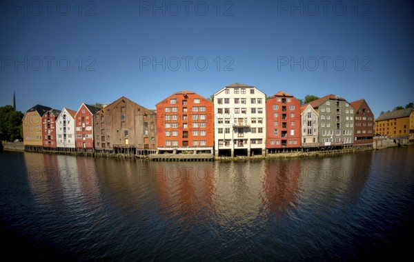 Warehouse city, picturesque colourful houses and commercial buildings on the river Nidelva, pile dwellings, Trondheim, Trøndelag, Norway, Scandinavia, Europe, adventure travel, tourism, gastronomy, commercial buildings, commercial district, property tax, commercial buildings, Hurtigruten, Hurtigruten trip, real estate, cruise, NOR, travel, destination, sea voyage, sightseeing, warehouses, tourism, Trøndelag, residential area, living and living, residential area, residential buildings, residential quality, residential quarter, housing estate, blue sky, colourful house facades, near the bridge Gamle Bybro, Norwegian, Scandinavian, touristy