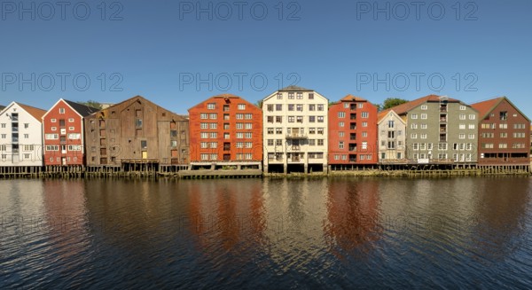 Warehouse city, picturesque colourful houses and commercial buildings on the river Nidelva, pile dwellings, Trondheim, Trøndelag, Norway, Scandinavia, Europe, adventure travel, tourism, gastronomy, commercial buildings, commercial district, property tax, commercial buildings, Hurtigruten, Hurtigruten trip, real estate, cruise, NOR, travel, destination, sea voyage, sightseeing, warehouses, tourism, Trøndelag, residential area, living and living, residential area, residential buildings, residential quality, residential quarter, housing estate, blue sky, colourful house facades, near the bridge Gamle Bybro, Norwegian, Scandinavian, touristy