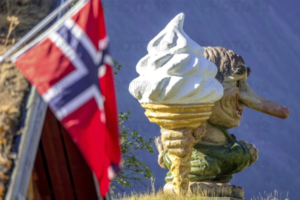 Norwegian troll with ice cream and Norwegian flag, Innfjorden, Møre og Romsdal, Norway, Scandinavia, Europe, adventure trip, mountain spirit, mythical creature, flags, tourism, Hurtigruten, Hurtigruten trip, cruise, mythology, Møre og Romsdal, NOR, travel, destination, sea trip, sightseeing, tourism, troll, forest spirit, Norwegian, Norwegian flag, Scandinavian, touristic