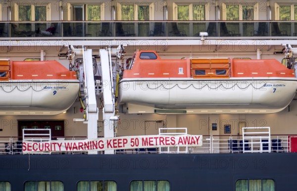 Ship RMS Queen Elizabeth, warning to sea pirates, security warning keep 50 metres away, lifeboats, Geiranger, Møre og Romsdal, Norway, Scandinavia, Europe, adventure travel, mountainside, tourism, Hurtigruten, Hurtigruten voyage, cabin window, cruise, cruise ship, Møre og Romsdal, NOR, passenger ship, shipping company Hurtigruten AS, travel, destination, Royal Mail Ship, ship, sea voyage, sightseeing, tourism, Norwegian, Scandinavian, touristic