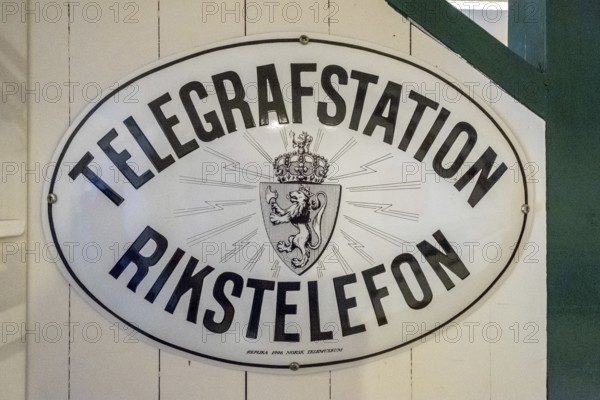 Travel by Flam Railway, Iron Railway, White sign with black lettering, TELEGRAFSTATION RINKSTELEFON, Flåm, Sogn og Fjordane, Norway, Scandinavia, Europe, Flåm, NOR, travel, tourism, destination, sightseeing, sea voyage, Hurtigruten, Hurtigruten voyage, tourism, Norwegian, Scandinavian, tourist, cruise, adventure trip, labelling, information
