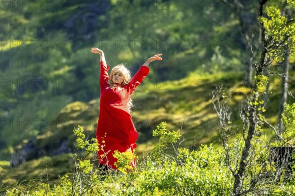 Woman dressed in red is a Huldra, fairy, legendary figure, Kjosfossen waterfall, waterfall near Fureberget, dancer in red dress, rock faces, Flåm, Sogn og Fjordane, Norway, Scandinavia, Europe, Flåm, NOR, travel, tourism, destination, sightseeing, sea voyage, Hurtigruten, Hurtigruten trip, tourism, Norwegian, Scandinavian, touristic, cruise, adventure trip, waterfall, waterfall, mountains, trees, meadows, Flamsbahn, Flamsbana, train journey, tour, travel with the Flam Railway, Flam Railway