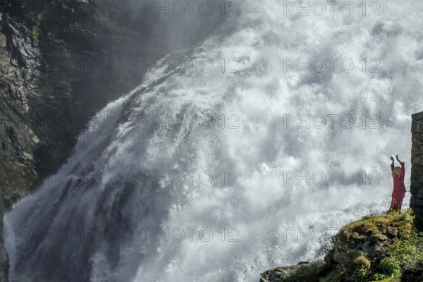 Woman dressed in red is a Huldra, fairy, legendary figure, Kjosfossen waterfall, waterfall near Fureberget, dancer in red dress, rock faces, Flåm, Sogn og Fjordane, Norway, Scandinavia, Europe, Flåm, NOR, travel, tourism, destination, sightseeing, sea voyage, Hurtigruten, Hurtigruten trip, tourism, Norwegian, Scandinavian, tourist, cruise, adventure trip, water, waters, mountains, waterfall, Flamsbahn, Flamsbana, travelling on the Flam Railway, Flam Railway
