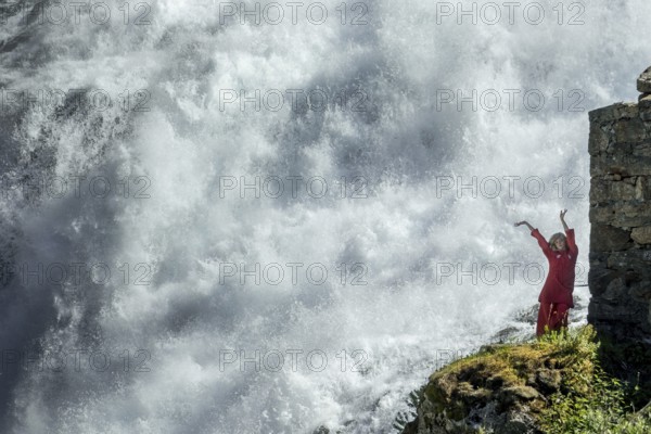 Red dressed woman is a Huldra, fairy, legendary figure, Kjosfossen waterfall, waterfall near Fureberget, dancer in red dress, rock walls, Flåm, Sogn og Fjordane, Norway, Scandinavia, Europe, Flåm, NOR, travel, tourism, destination, sightseeing, sea voyage, Hurtigruten, Hurtigruten trip, tourism, Norwegian, Scandinavian, touristic, cruise, adventure trip, waterfall, stone wall, mountains, Flamsbahn, Flamsbana, train journey, tour, travel with the Flam Railway, Flam Railway