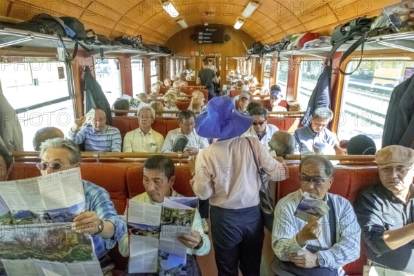 Travel by Flam Railway, iron railway journey, tourists in Flåmsbana, Flåm, Sogn og Fjordane, Norway, Scandinavia, Europe, Flåm, NOR, travel, tourism, destination, sightseeing, sea voyage, Hurtigruten, Hurtigruten trip, tourism, Norwegian, Scandinavian, tourist, cruise, adventure trip, reading, sitting, walking