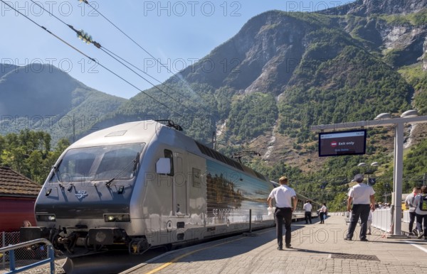 Journey with the Flam Railway, iron railway track, people at the railway track, NSB train, cobbled station with display board, mountains, forests, Flåm, Sogn og Fjordane, Norway, Scandinavia, Europe, Flåm, NOR, travel, tourism, destination, sightseeing, sea voyage, Hurtigruten, Hurtigruten trip, tourism, Norwegian, Scandinavian, tourist, cruise, adventure trip, conductor, Flam Railway, train journey, Aurlandsfjords, high mountains