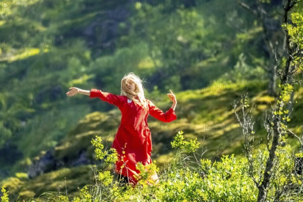 Woman dressed in red is a Huldra, fairy, legendary figure, Kjosfossen waterfall, waterfall near Fureberget, dancer in red dress, rock faces, Flåm, Sogn og Fjordane, Norway, Scandinavia, Europe, Flåm, NOR, travel, tourism, destination, sightseeing, sea voyage, Hurtigruten, Hurtigruten trip, tourism, Norwegian, Scandinavian, touristic, cruise, adventure trip, waterfall, waterfall, mountains, trees, meadows, Flamsbahn, Flamsbana, train journey, tour, travel with the Flam Railway, Flam Railway