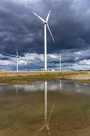 Wind farm, wind turbines, south of the village of Holzweiler, in the Rhenish lignite mining area south of the Garzweiler open-cast mine, dark storm clouds, North Rhine-Westphalia, Germany