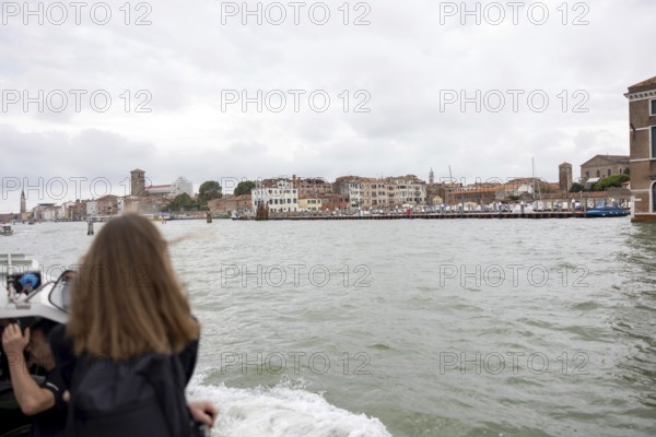 Venice, Italy - 2 September 2025: A woman takes a photo with her mobile phone on the way to the Lido on a passenger boat during the 82nd Venice International Film Festival