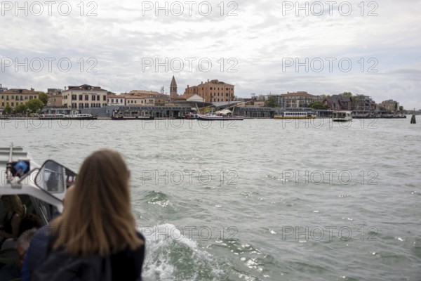 Venice, Italy - 2 September 2025: A woman takes a photo with her mobile phone on the way to the Lido on a passenger boat during the 82nd Venice International Film Festival