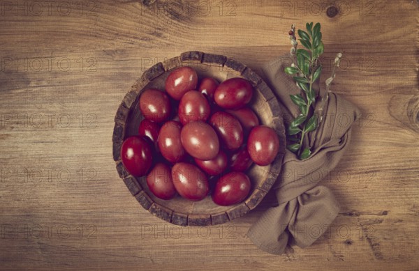 Painted eggs in a wooden bowl, red, painted madder dye, powder from the roots of endro, with onion husks, top view, Easter, Georgia