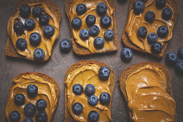 Rye bread with peanut paste and fresh blueberries, top view, no people