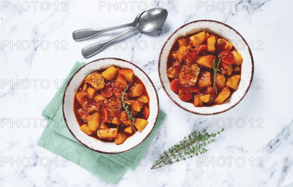 Meat goulash with potatoes and carrots, sweet peppers, in a saucepan, top view, traditional Hungarian soup, homemade, no people