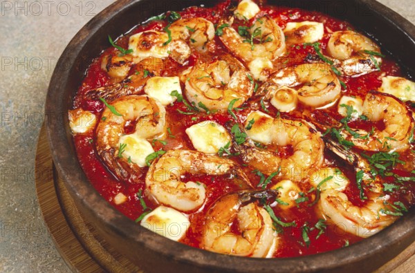 Saganaki with shrimp, in a clay pan, Greek dish, shrimp in tomato sauce, feta cheese, homemade, no people