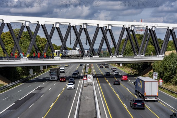 The new railway bridge over the A1 motorway at the Dortmund-Unna motorway junction, steel truss bridge, weighing 2000 tonnes, 124 metre span, new construction due to the widening of the A1 in this area, regional trains, ICE trains and goods trains run here between Dortmund and Soest, North Rhine-Westphalia, Germany