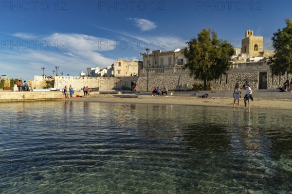 City beach Spiaggetta del Molo or Spiaggia dei Bambini and the old town centre of Otranto, Apulia, Italy