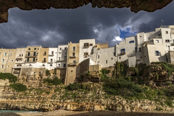 Houses above the cliffs on the town beach Spiaggia Llama Monachile in Polignano a Mare, Apulia, Italy