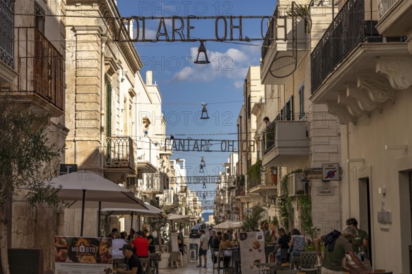 The lyrics of the song VOLARE Nel blu dipinto di blu as illumination over the pedestrian zone Via Roma, Polignano a Mare, Apulia, Italy