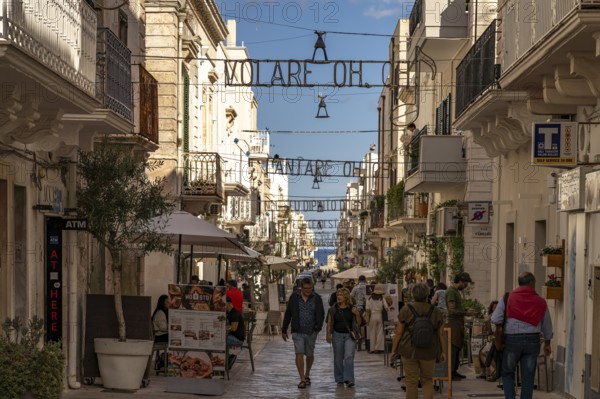 The lyrics of the song VOLARE Nel blu dipinto di blu as illumination over the pedestrian zone Via Roma, Polignano a Mare, Apulia, Italy