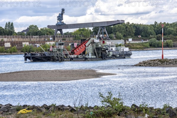 Bucket chain dredger at work on the Rhine near Duisburg, between the Neuenkamper Rhine Bridge and the Friedrich-Ebert Bridge in Ruhrpott, dredging the navigation channel, North Rhine-Westphalia, Germany
