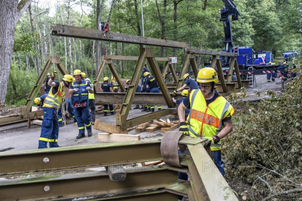 Construction of a temporary bridge over a slipped road crossing a stream, by the bridge construction section of the THW, 18 metre long steel bridge of the Krupp-D type, is assembled in around 8 hours, large-scale exercise FÜLEX25 lasting several days, of the THW North Rhine-Westphalia regional association, over 3500 volunteers from the 127 North Rhine-Westphalia local associations practise on 4 weekends, many different deployment scenarios