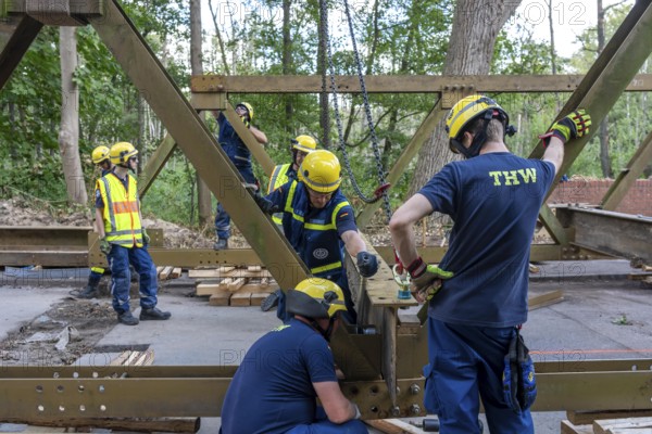 Construction of a temporary bridge over a slipped road crossing a stream, by the bridge construction section of the THW, 18 metre long steel bridge of the Krupp-D type, is assembled in around 8 hours, large-scale exercise FÜLEX25 lasting several days, of the THW North Rhine-Westphalia regional association, over 3500 volunteers from the 127 North Rhine-Westphalia local associations practise on 4 weekends, many different deployment scenarios