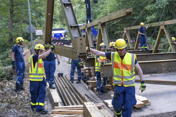 Construction of a temporary bridge over a slipped road crossing a stream, by the bridge construction section of the THW, 18 metre long steel bridge of the Krupp-D type, is assembled in around 8 hours, large-scale exercise FÜLEX25 lasting several days, of the THW North Rhine-Westphalia regional association, over 3500 volunteers from the 127 North Rhine-Westphalia local associations practise on 4 weekends, many different deployment scenarios