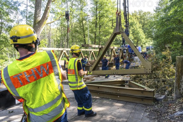 Construction of a temporary bridge over a slipped road crossing a stream, by the bridge construction section of the THW, 18 metre long steel bridge of the Krupp-D type, is assembled in around 8 hours, large-scale exercise FÜLEX25 lasting several days, of the THW North Rhine-Westphalia regional association, over 3500 volunteers from the 127 North Rhine-Westphalia local associations practise on 4 weekends, many different deployment scenarios
