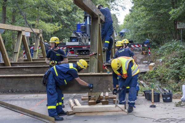 Construction of a temporary bridge over a slipped road crossing a stream, by the bridge construction section of the THW, 18 metre long steel bridge of the Krupp-D type, is assembled in around 8 hours, large-scale exercise FÜLEX25 lasting several days, of the THW North Rhine-Westphalia regional association, over 3500 volunteers from the 127 North Rhine-Westphalia local associations practise on 4 weekends, many different deployment scenarios