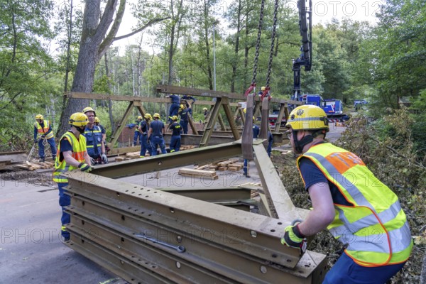 Construction of a temporary bridge over a slipped road crossing a stream, by the bridge construction section of the THW, 18 metre long steel bridge of the Krupp-D type, is assembled in around 8 hours, large-scale exercise FÜLEX25 lasting several days, of the THW North Rhine-Westphalia regional association, over 3500 volunteers from the 127 North Rhine-Westphalia local associations practise on 4 weekends, many different deployment scenarios