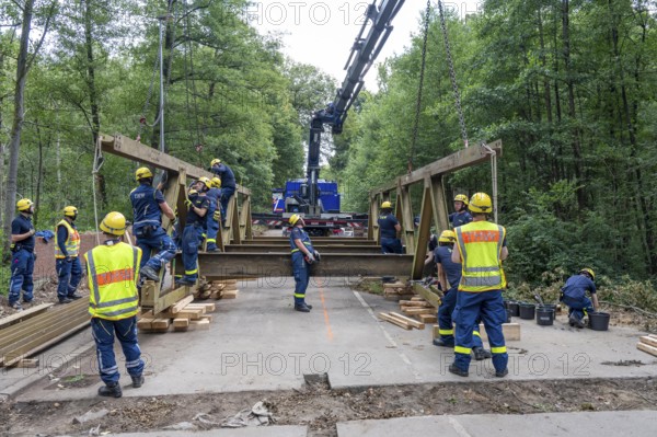 Construction of a temporary bridge over a slipped road crossing a stream, by the bridge construction section of the THW, 18 metre long steel bridge of the Krupp-D type, is assembled in around 8 hours, large-scale exercise FÜLEX25 lasting several days, of the THW North Rhine-Westphalia regional association, over 3500 volunteers from the 127 North Rhine-Westphalia local associations practise on 4 weekends, many different deployment scenarios