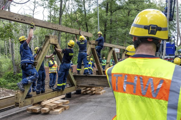Construction of a temporary bridge over a slipped road crossing a stream, by the bridge construction section of the THW, 18 metre long steel bridge of the Krupp-D type, is assembled in around 8 hours, large-scale exercise FÜLEX25 lasting several days, of the THW North Rhine-Westphalia regional association, over 3500 volunteers from the 127 North Rhine-Westphalia local associations practise on 4 weekends, many different deployment scenarios