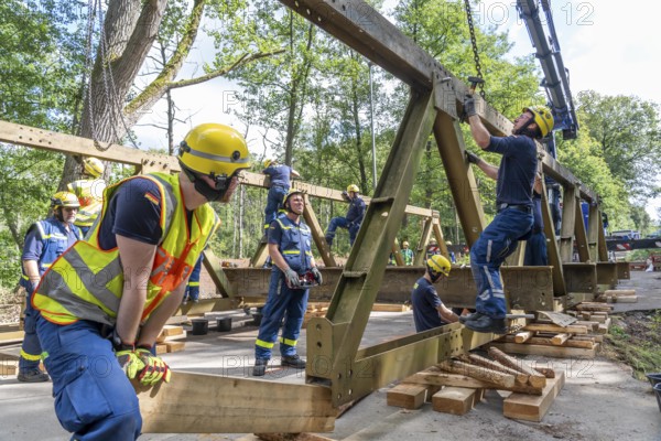 Construction of a temporary bridge over a slipped road crossing a stream, by the bridge construction section of the THW, 18 metre long steel bridge of the Krupp-D type, is assembled in around 8 hours, large-scale exercise FÜLEX25 lasting several days, of the THW North Rhine-Westphalia regional association, over 3500 volunteers from the 127 North Rhine-Westphalia local associations practise on 4 weekends, many different deployment scenarios