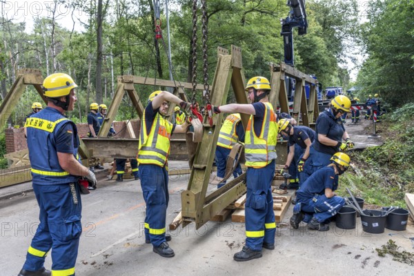 Construction of a temporary bridge over a slipped road crossing a stream, by the bridge construction section of the THW, 18 metre long steel bridge of the Krupp-D type, is assembled in around 8 hours, large-scale exercise FÜLEX25 lasting several days, of the THW North Rhine-Westphalia regional association, over 3500 volunteers from the 127 North Rhine-Westphalia local associations practise on 4 weekends, many different deployment scenarios