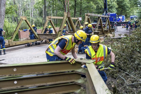 Construction of a temporary bridge over a slipped road crossing a stream, by the bridge construction section of the THW, 18 metre long steel bridge of the Krupp-D type, is assembled in around 8 hours, large-scale exercise FÜLEX25 lasting several days, of the THW North Rhine-Westphalia regional association, over 3500 volunteers from the 127 North Rhine-Westphalia local associations practise on 4 weekends, many different deployment scenarios