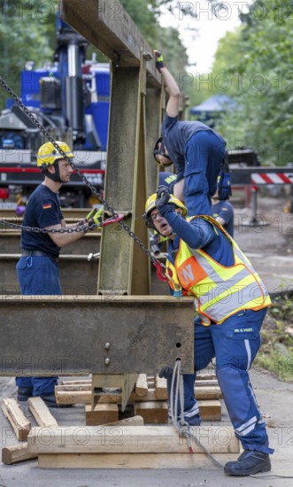 Construction of a temporary bridge over a slipped road crossing a stream, by the bridge construction section of the THW, 18 metre long steel bridge of the Krupp-D type, is assembled in around 8 hours, large-scale exercise FÜLEX25 lasting several days, of the THW North Rhine-Westphalia regional association, over 3500 volunteers from the 127 North Rhine-Westphalia local associations practise on 4 weekends, many different deployment scenarios