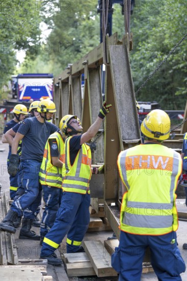Construction of a temporary bridge over a slipped road crossing a stream, by the bridge construction section of the THW, 18 metre long steel bridge of the Krupp-D type, is assembled in around 8 hours, large-scale exercise FÜLEX25 lasting several days, of the THW North Rhine-Westphalia regional association, over 3500 volunteers from the 127 North Rhine-Westphalia local associations practise on 4 weekends, many different deployment scenarios