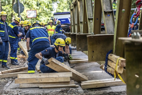 Construction of a temporary bridge over a slipped road crossing a stream, by the bridge construction section of the THW, 18 metre long steel bridge of the Krupp-D type, is assembled in around 8 hours, large-scale exercise FÜLEX25 lasting several days, of the THW North Rhine-Westphalia regional association, over 3500 volunteers from the 127 North Rhine-Westphalia local associations practise on 4 weekends, many different deployment scenarios